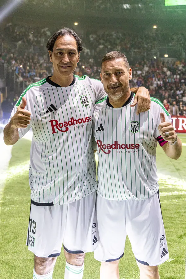 Due ex calciatori in maglia bianca si salutano in campo