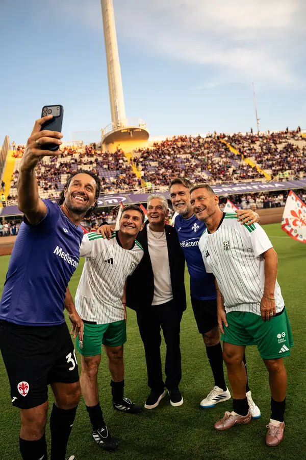 Selfie di gruppo in campo con il pubblico sullo sfondo